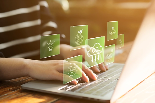 Manos trabajando con gráficos de consumo energético y elementos verdes que representan diseño web sustentable
